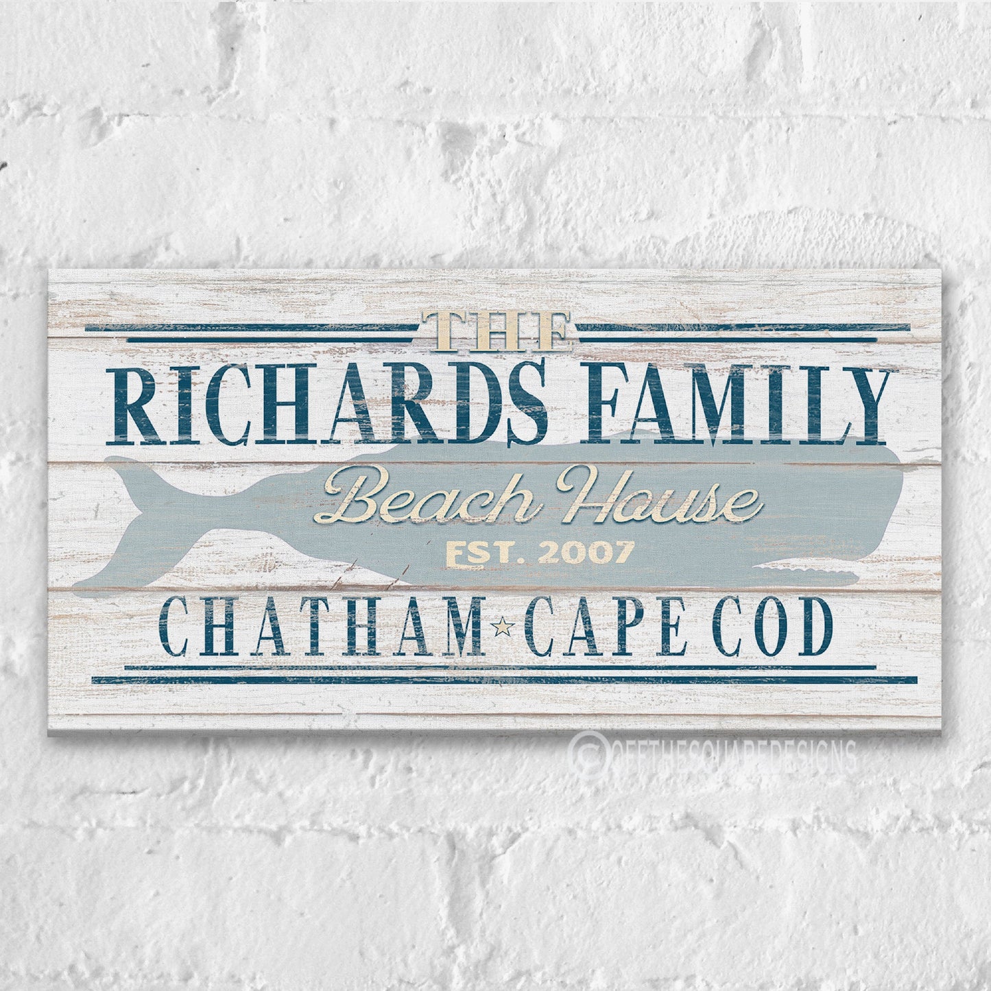 Beach house whale canvas art displayed above console table in coastal entryway