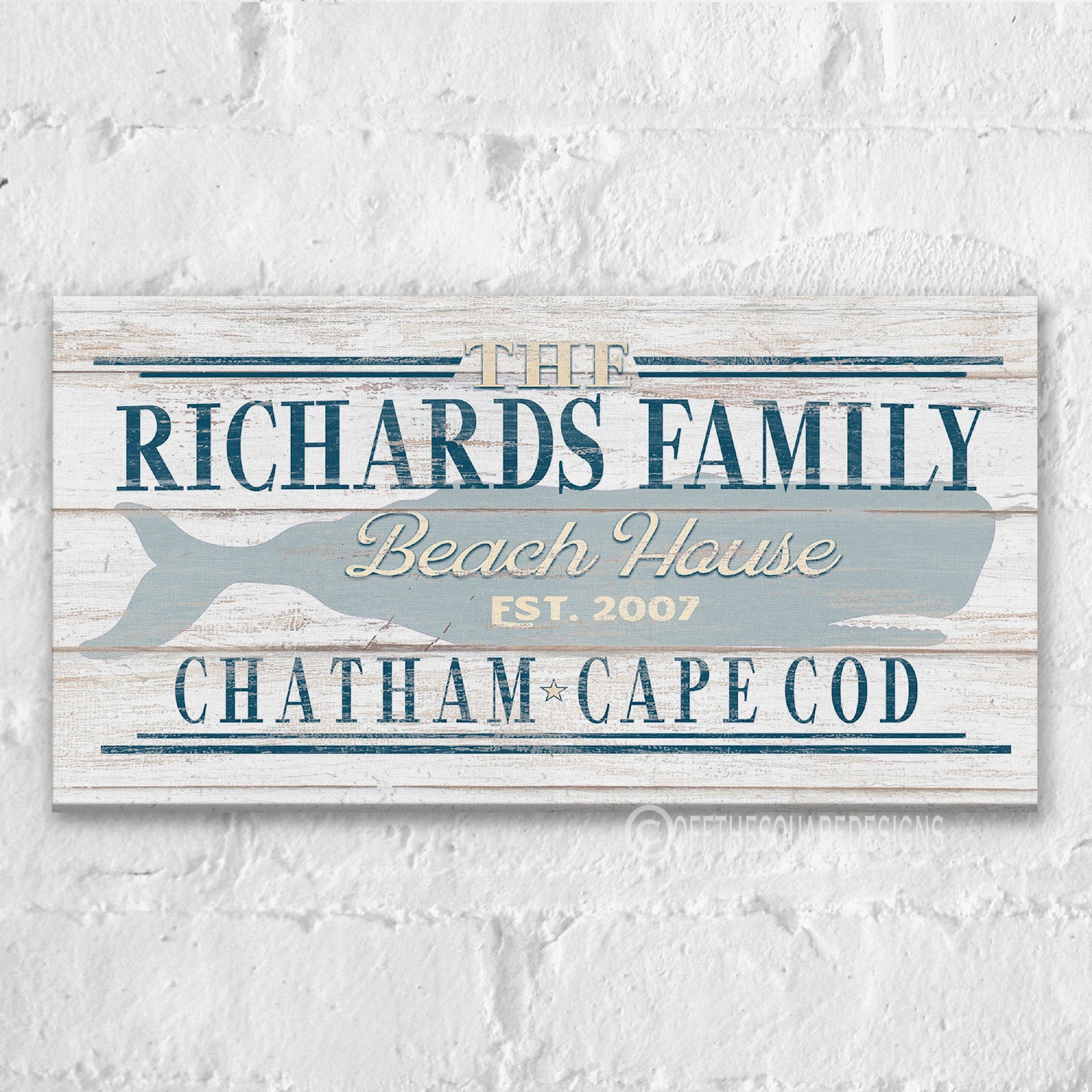 Beach house whale canvas art displayed above console table in coastal entryway