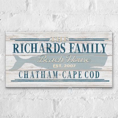 Beach house whale canvas art displayed above console table in coastal entryway