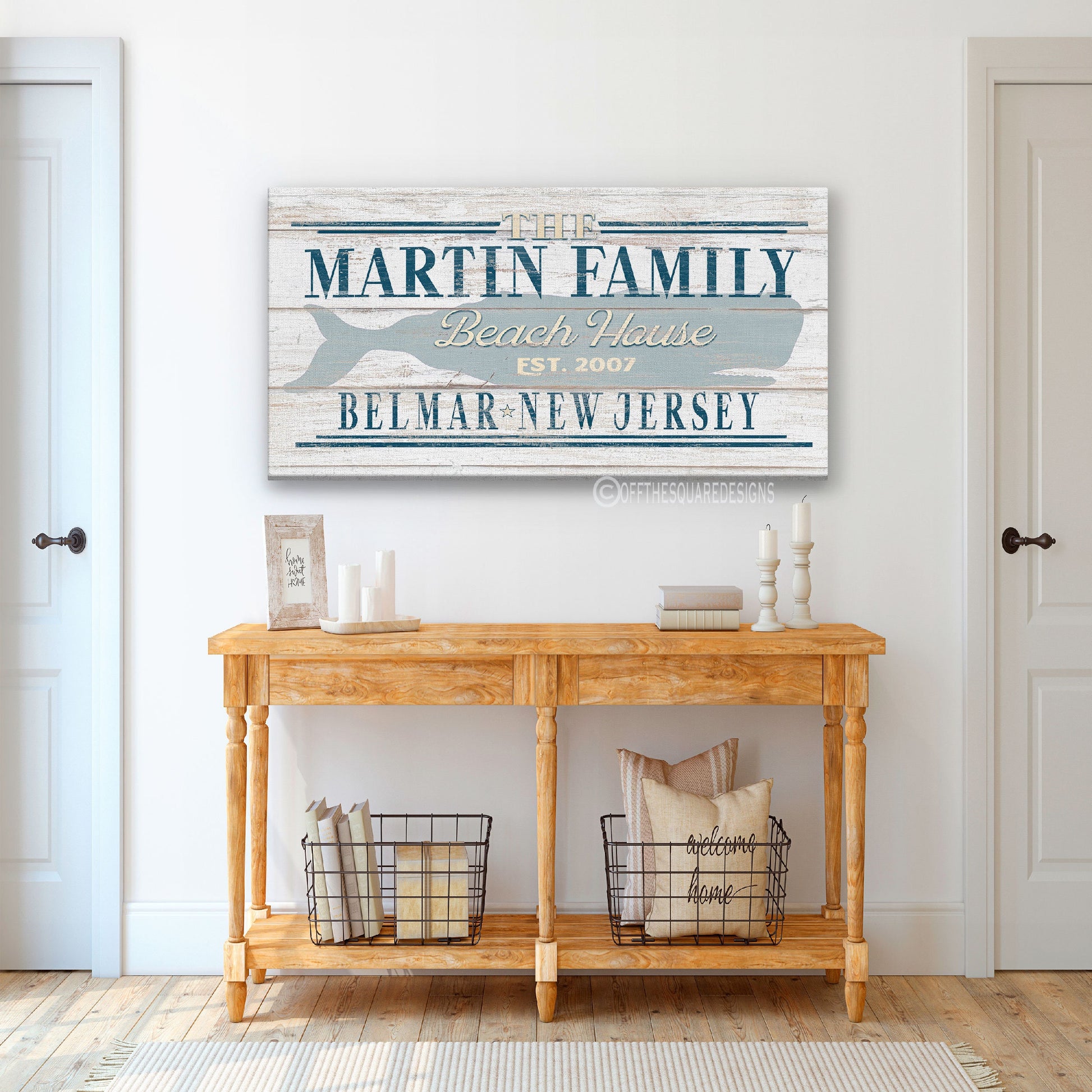 Beach house whale wall art in coastal living room setting with sofa and natural light