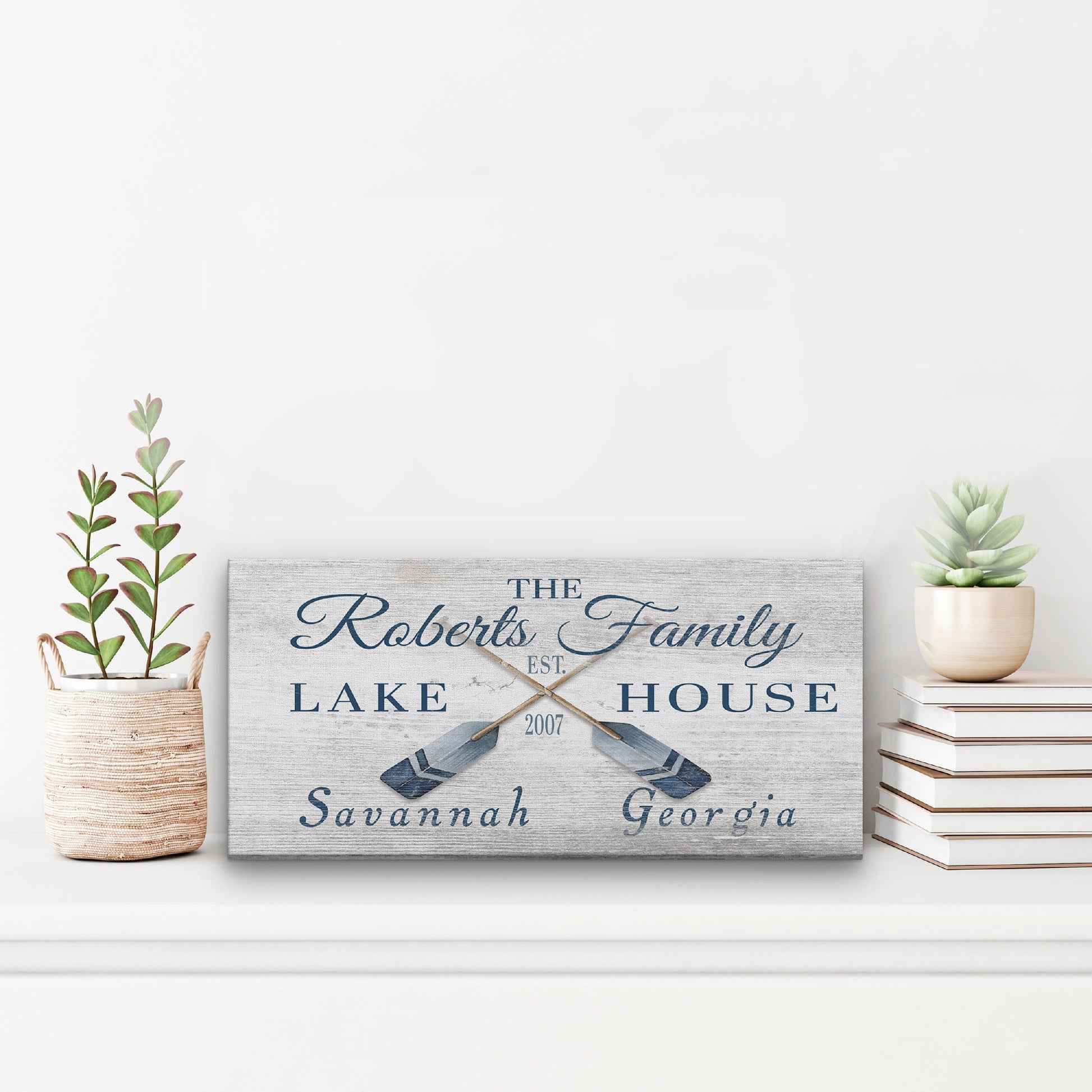Personalized coordinates sign as statement piece above fireplace on wood mantel in coastal home