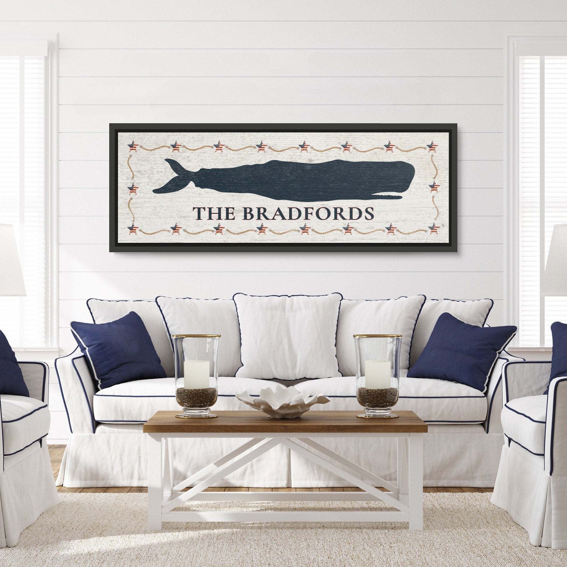 Framed whale canvas art above bed in serene coastal bedroom with nautical bedding