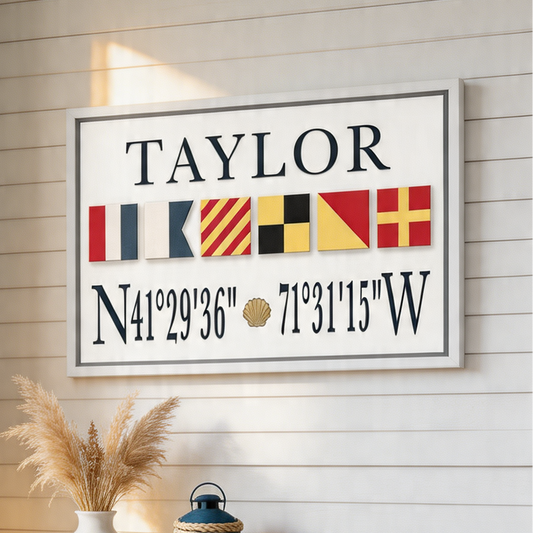 Framed nautical-themed wall art with 'TAYLOR' and coordinates on a wooden wall.